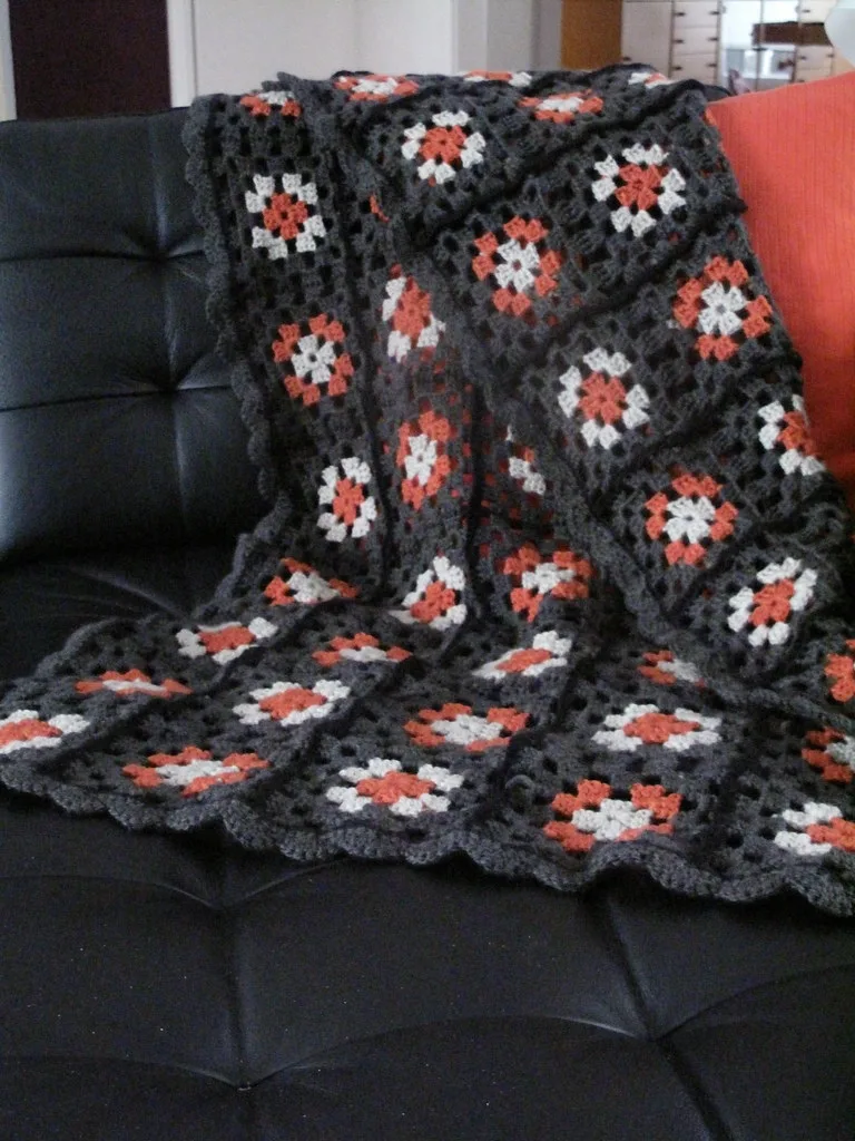 Plaid composé de carrés crochetés gris, blancs et corail