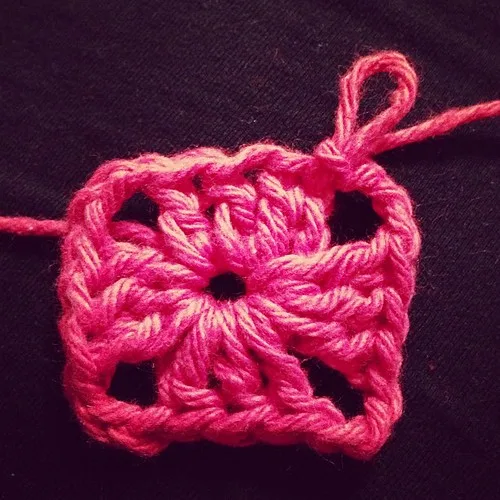 Gros plan sur les premières mailles d’un carré crocheté rose